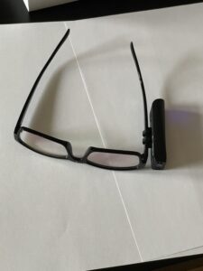 Zapnutý Orcam na rozložených okuliaroch